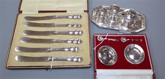 A set of six butter knives (cased), a pair of miniature patens and salt spoons (cased) and a four-piece plated condiment set